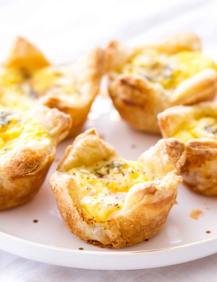Quiche cups with ham and cheddar cheese on a white plate