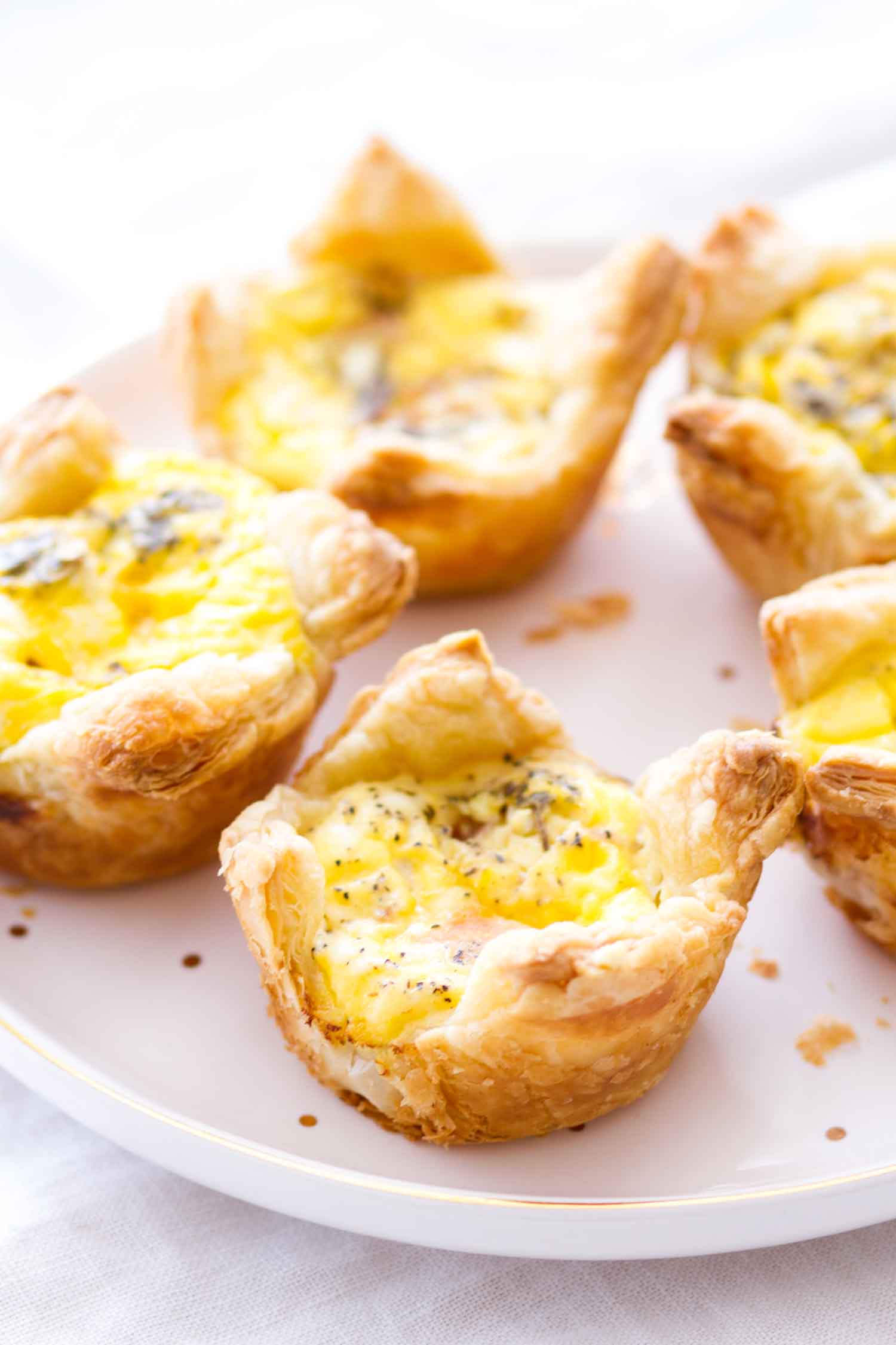 Quiche cups with ham and cheddar cheese on a white plate