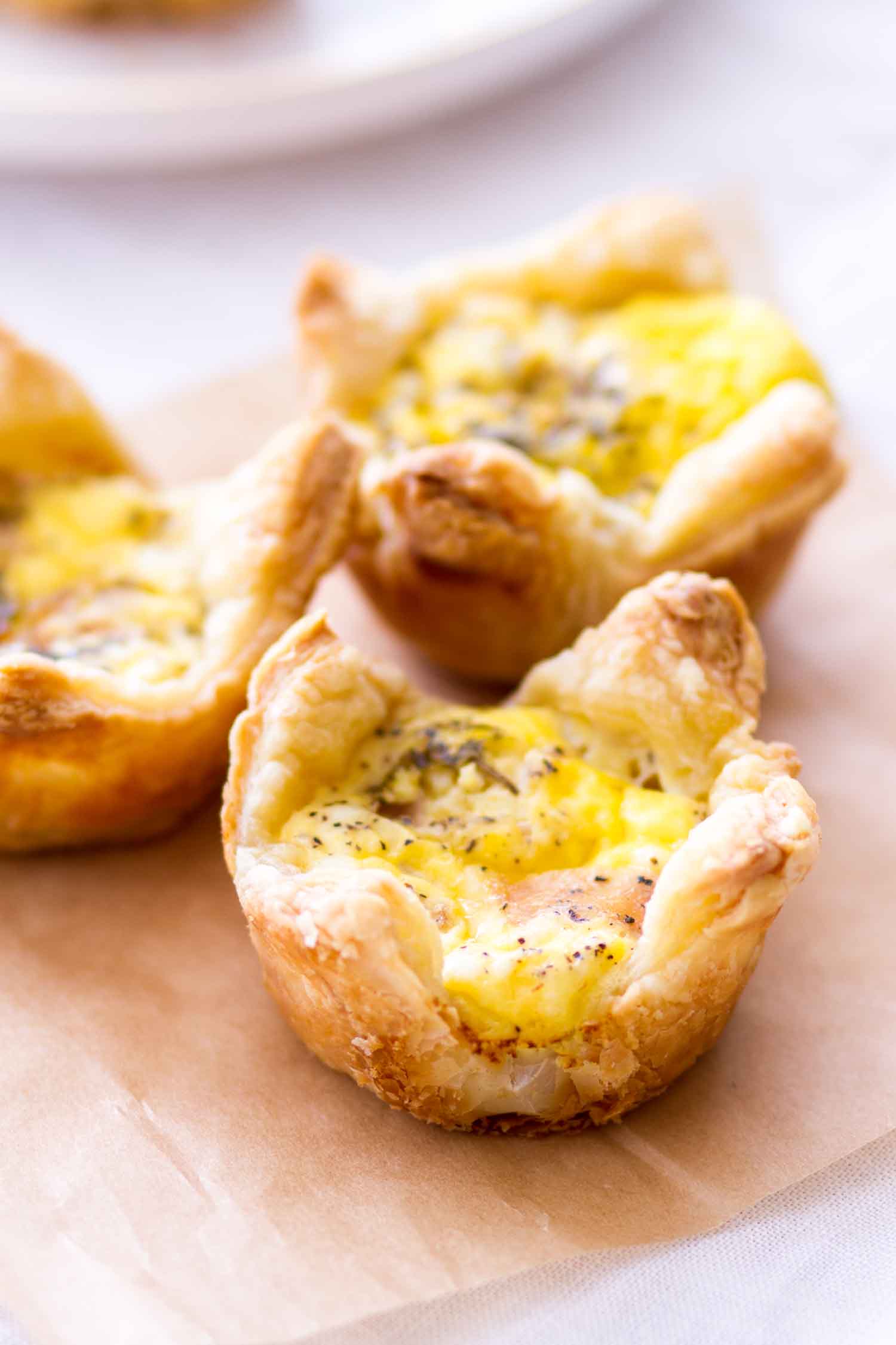 Quiche cups with ham and cheddar cheese on a piece of paper