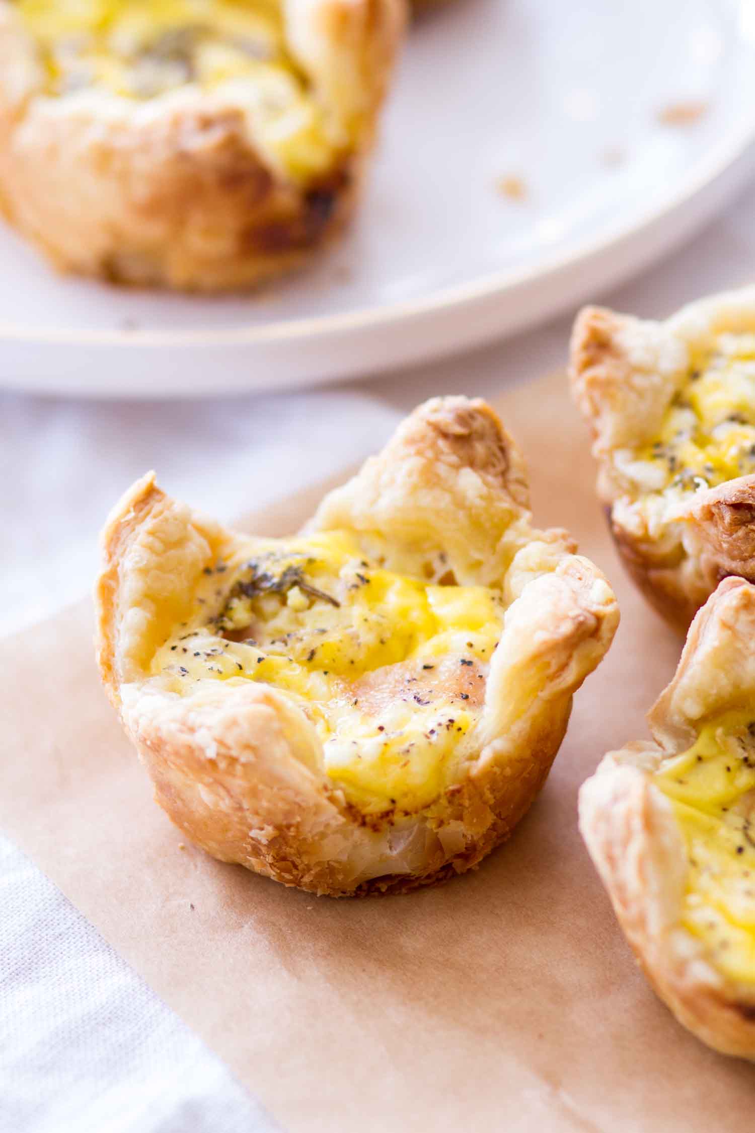 cheddar and ham quiche cups on brown parchment paper