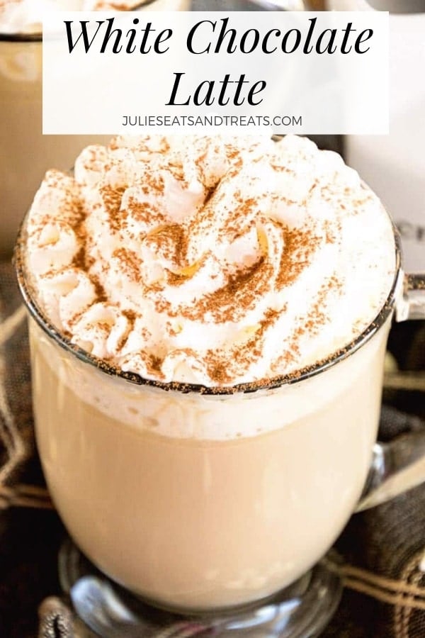 White chocolate latte in a glass mug topped with whipped cream and cinnamon