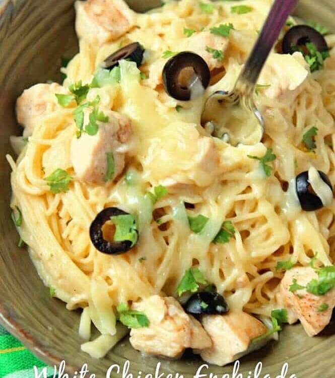 A green bowl of white chicken enchilada pasta with a fork in it