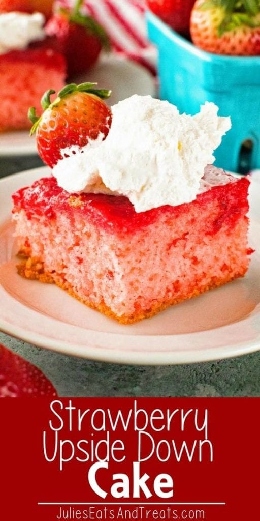 Slice of strawberry upside down cake topped with whipped cream and a strawberry on a white plate