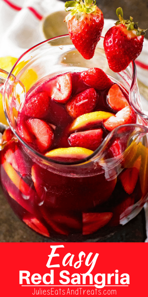 Easy Red Sangria in a glass pitcher with strawberries and lemon slices