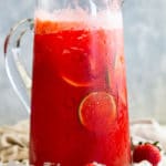 Glass pitcher of strawberry lemonade margarita sitting in ice