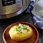 Baked Potato on brown plate in front of instant pot