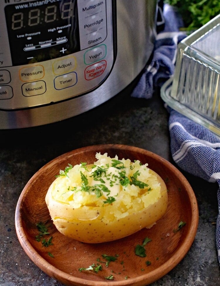 Baked Potato on brown plate in front of instant pot