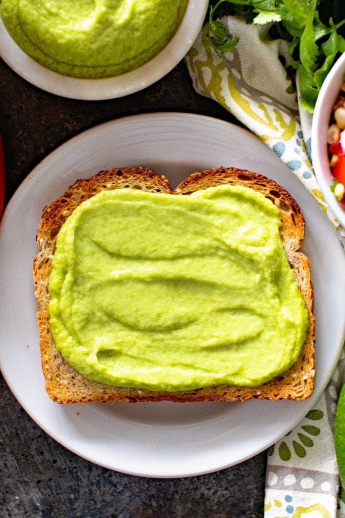 Toast with avocado butter on white plate