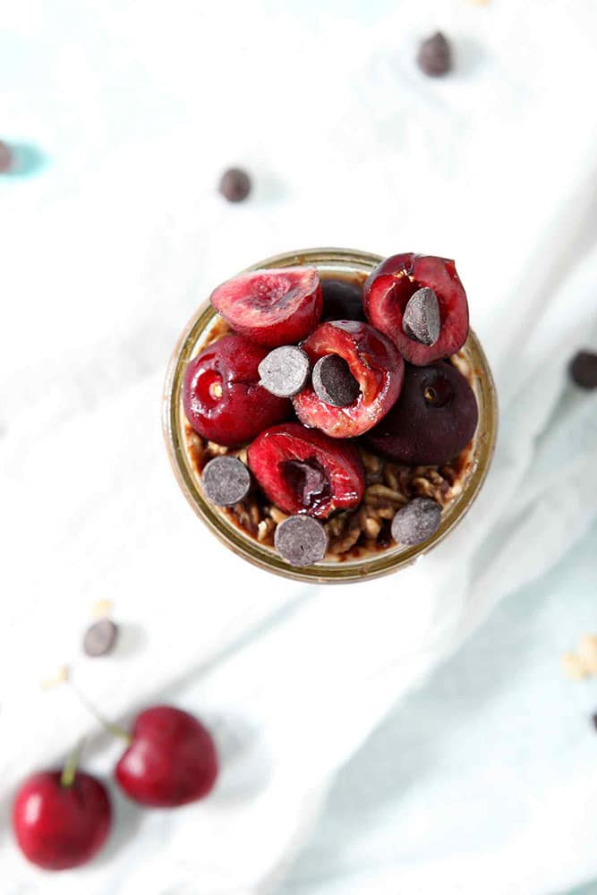 Close up of Cherry Overnight Oats Recipe from above, highlighting the fresh cherries and chocolate chips used as toppings