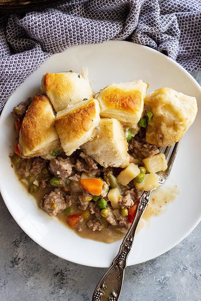 Beef Pot Pie Recipe in a white bowl with biscuits.