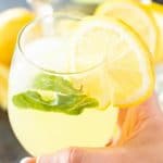 Hand Holding Sparkling Mint Lemonade in Glass