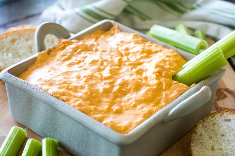 Buffalo chicken dip in square dish with celery