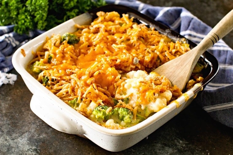 Casserole in a stone dish with a wooden spoon scooping