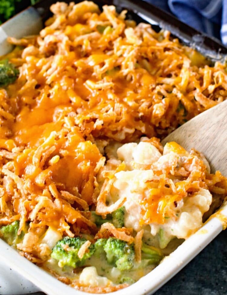 broccoli cauliflower cheese casserole with spoon in casserole dish