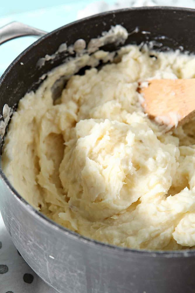 Make Ahead Mashed Potato Casserole is shown in a pot, just after mixing in all the ingredients, and before it is transferred to a baking dish to cook in the oven with additional cheese