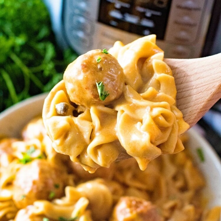 Spoon scooping swedish meatballs out of bowl