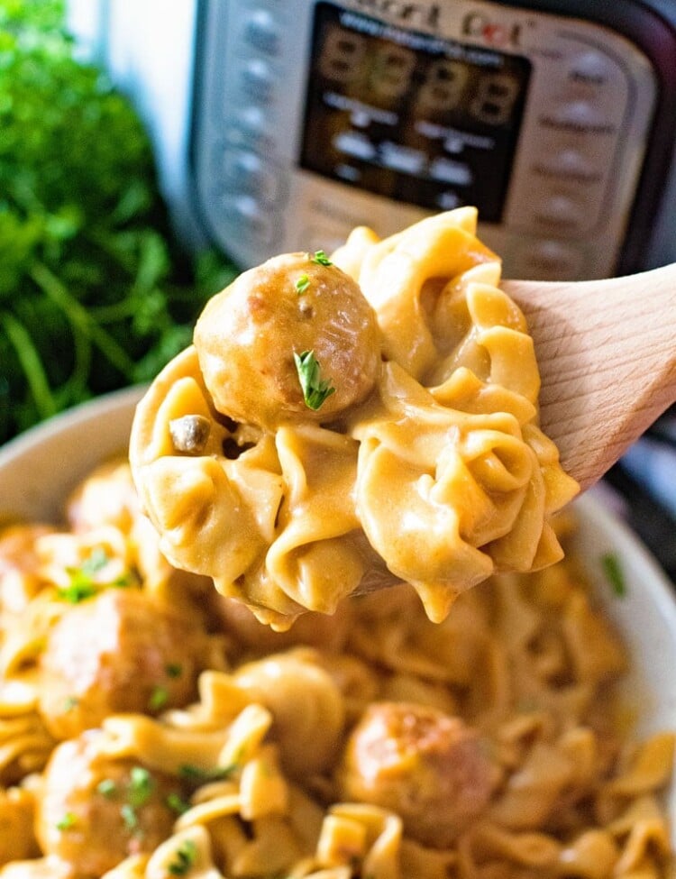 Spoon scooping swedish meatballs out of bowl