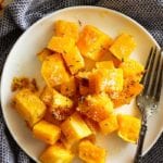 Parmesan roasted butternut squash chunks on a white plate