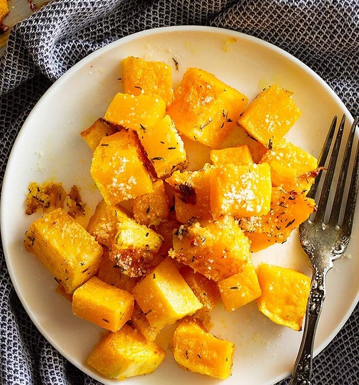 Parmesan roasted butternut squash chunks on a white plate