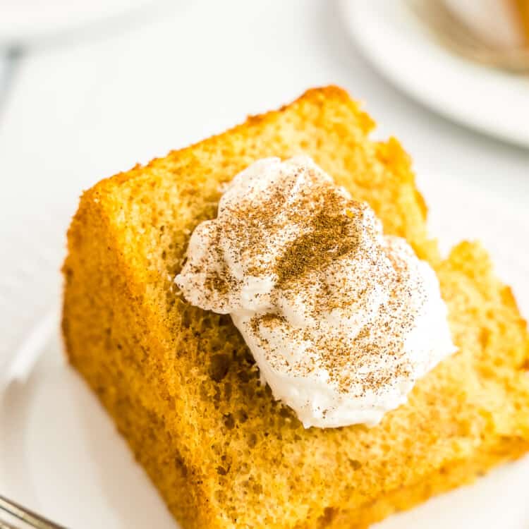 Pumpkin Angel Food Cake on white plate with cool whip