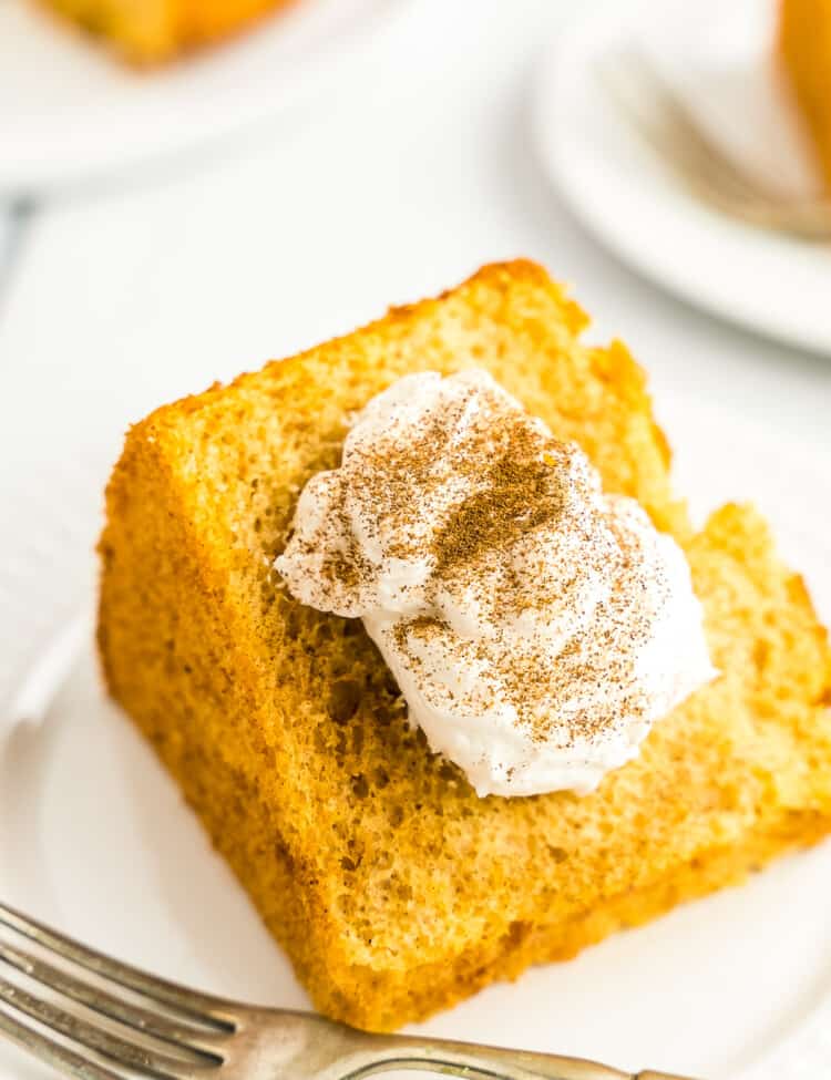 Pumpkin Angel Food Cake on white plate with cool whip