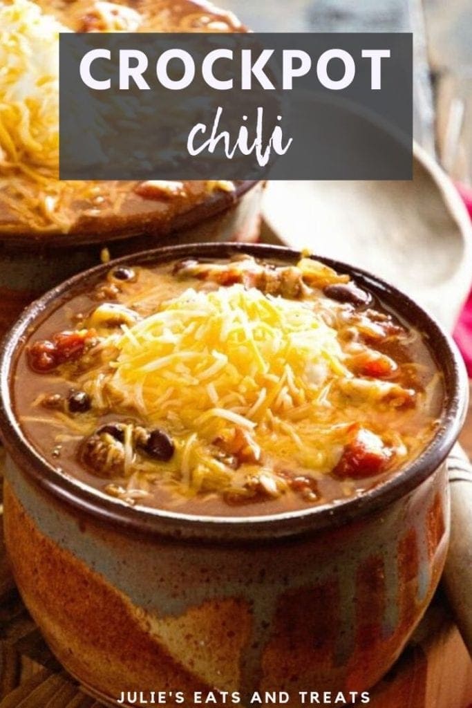 Brown bowl of crock pot chili topped with shredded cheese