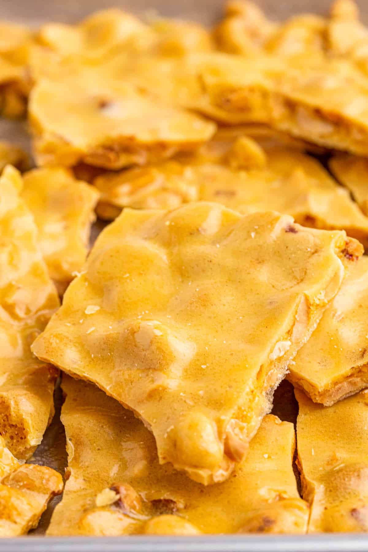 Microwave Peanut Brittle stacked on a pan