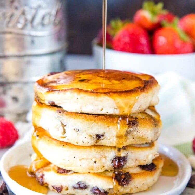 Stack of chocolate chip pancakes with syrup on a plate