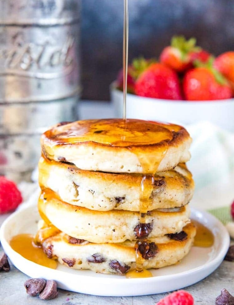 Stack of chocolate chip pancakes with syrup on a plate