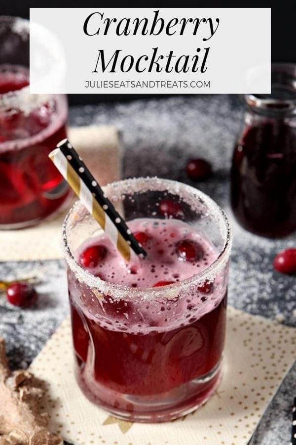 Cranberry mocktail in a glass with sugared rim and two straws