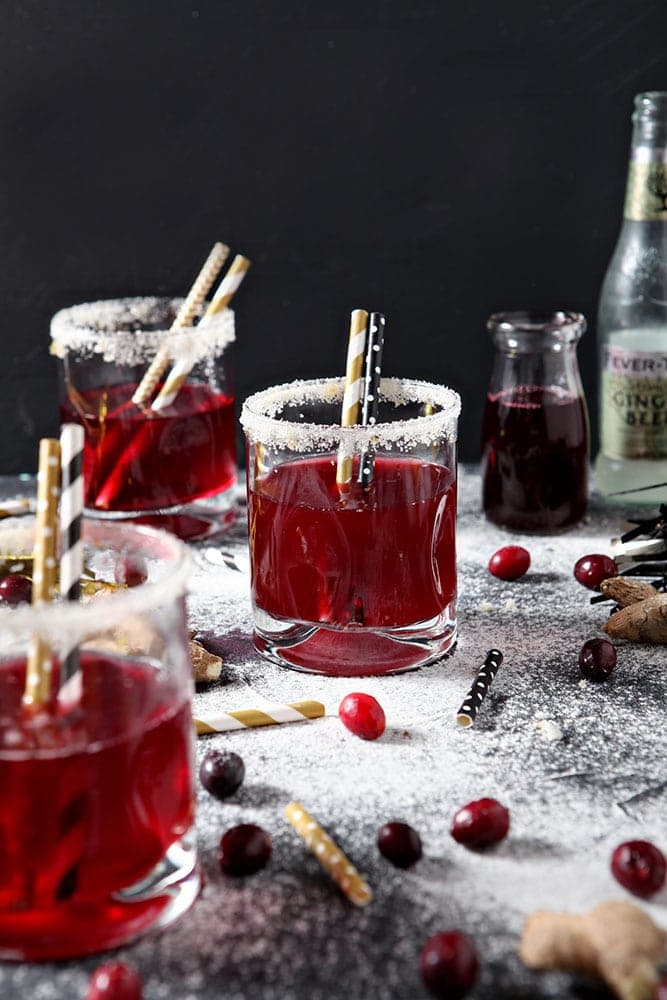 Three Sparkling Cranberry Mocktails are served on napkins with golden straws