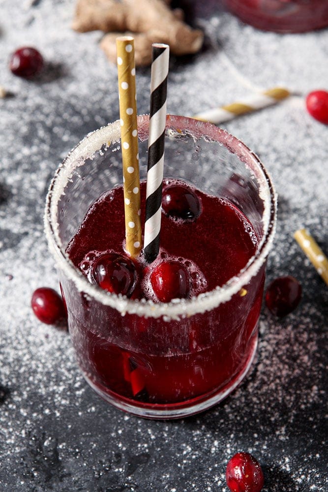 Close up of a Sparkling Cranberry Mocktail, surrounded by fresh cranberries