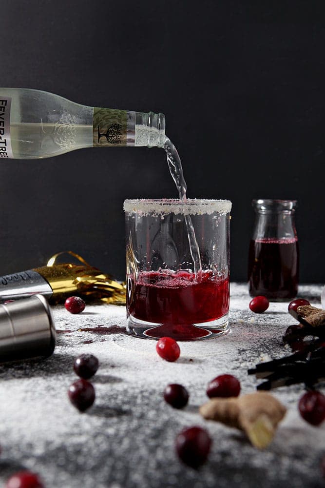 Ginger beer is poured into a glass to make a Sparkling Cranberry Mocktail