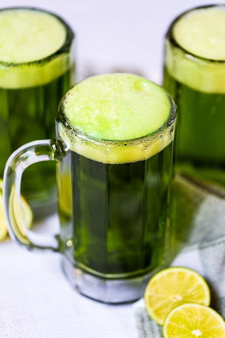 Frothy Green Beer in Mug with more in the background