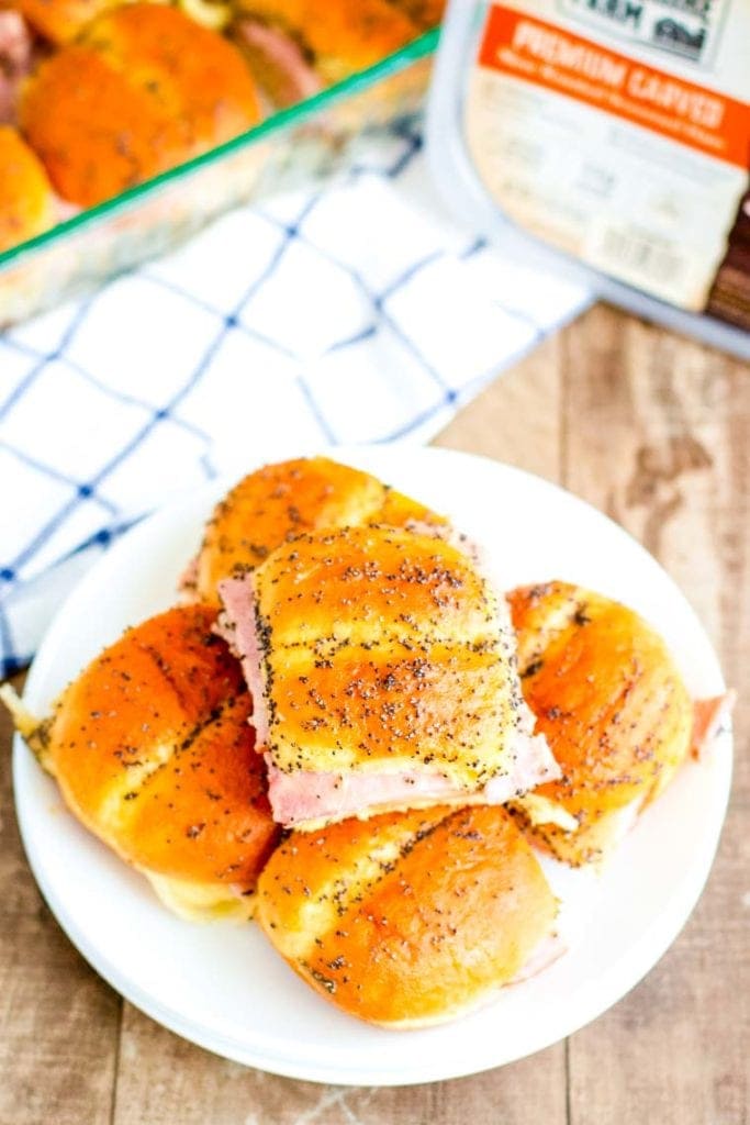 Overhead image of a white plate with a stack of ham and cheese sliders