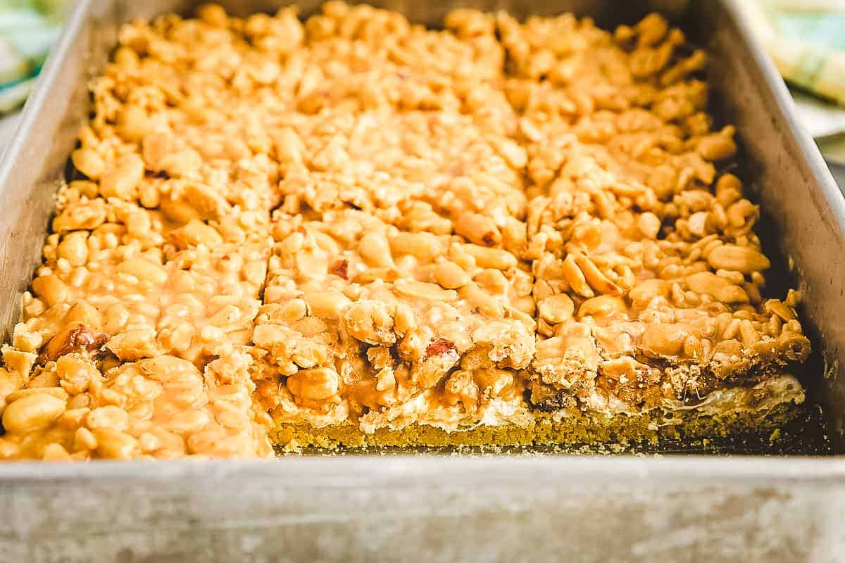 A pan of salted nut roll bars with two taken out in front row