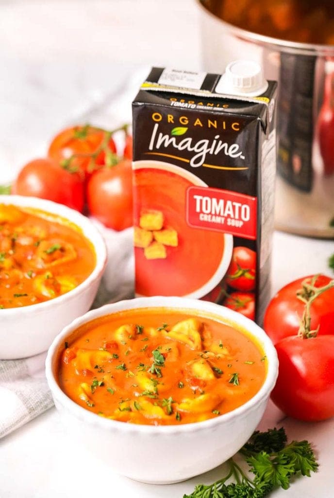 Two bowls of tomato soup with cheese tortellini