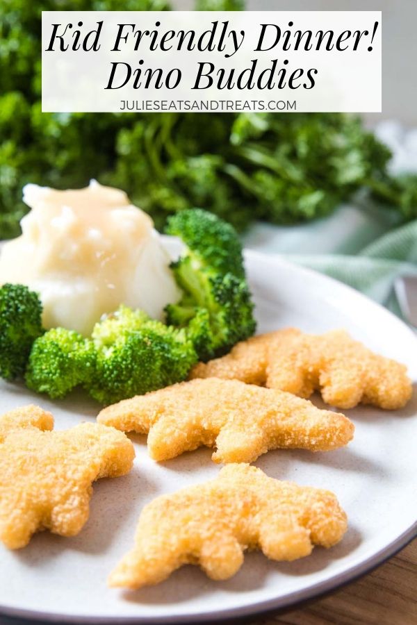 Dino chicken nuggets, mashed potatoes, gravy, and broccoli on a white plate