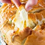 Hand pulling off a piece of garlic cheese pull apart bread