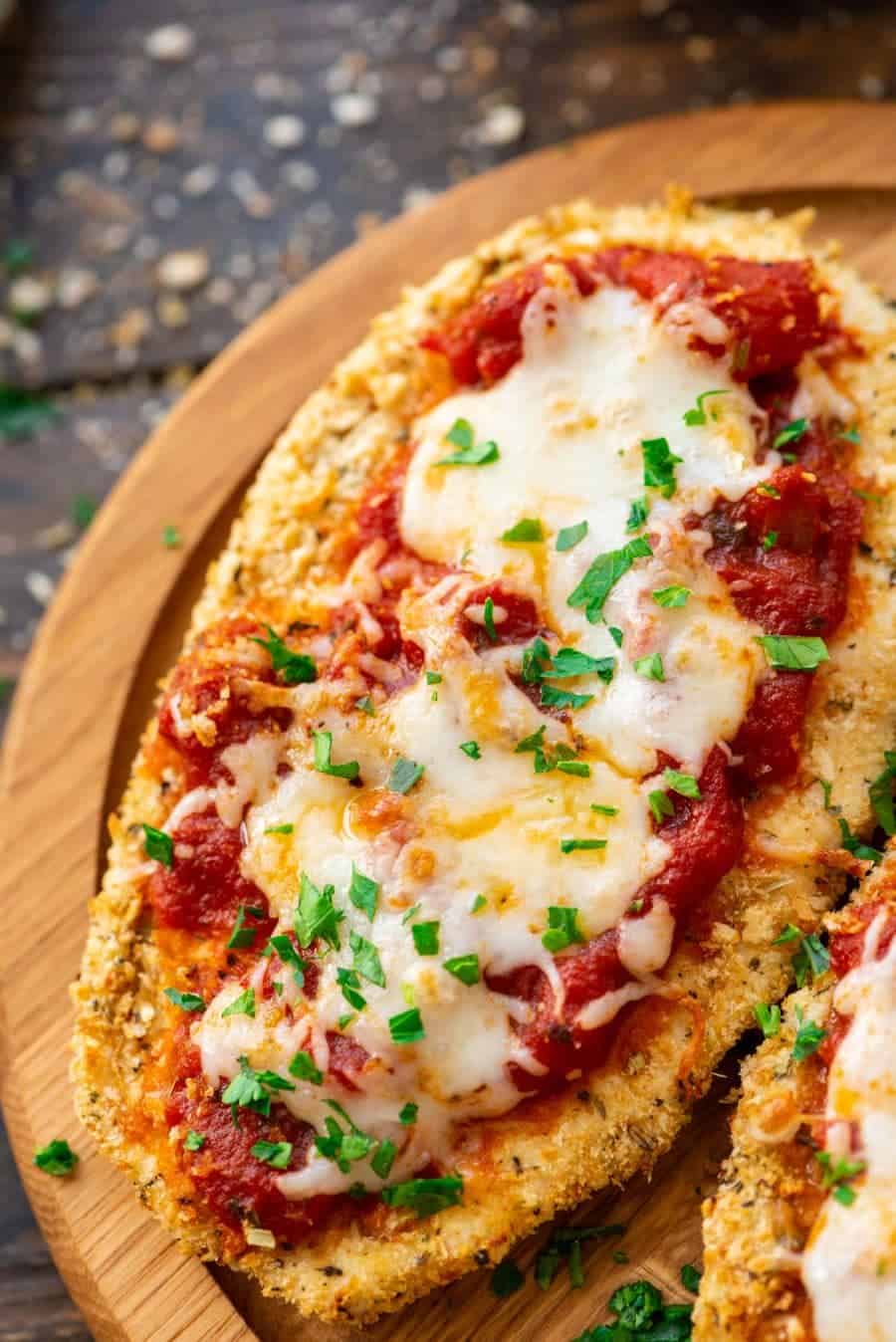 Chicken Parmesan on brown cutting board