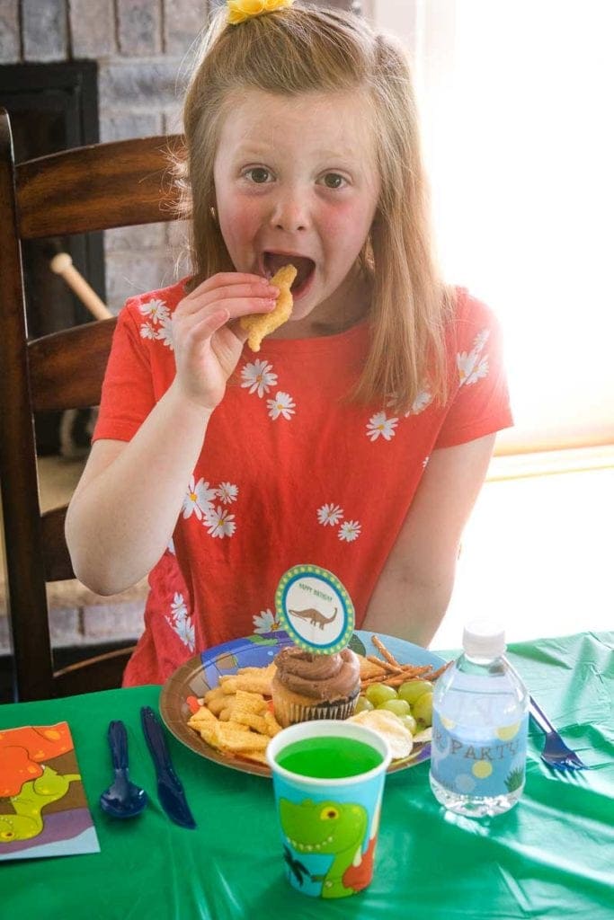 Child Eating Dino Buddies at Dinosaur Party