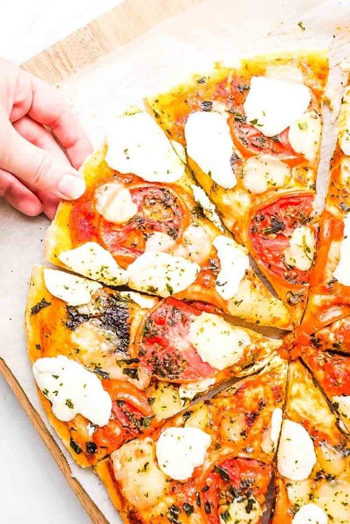 Hand taking slice of Margherita Pizza Recipe
