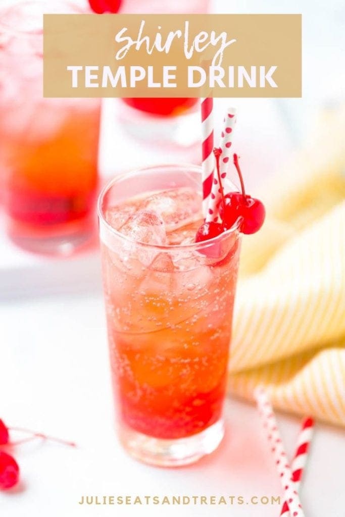 Shirley temple drink in a tall glass with cherries and two straws