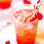 Tall Glass of Shirley Temple with cherries and two straws