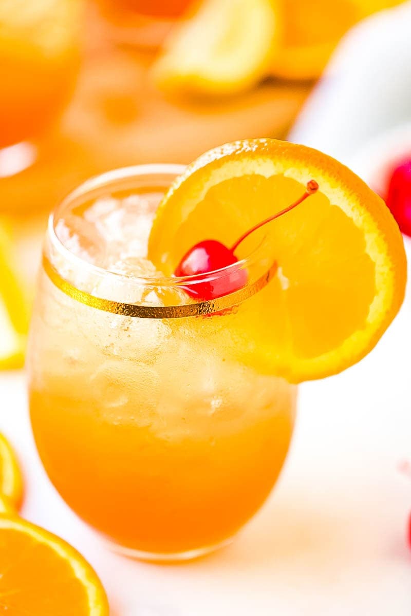 Glass of Amaretto Sour Drink with orange slice and cherry garnish
