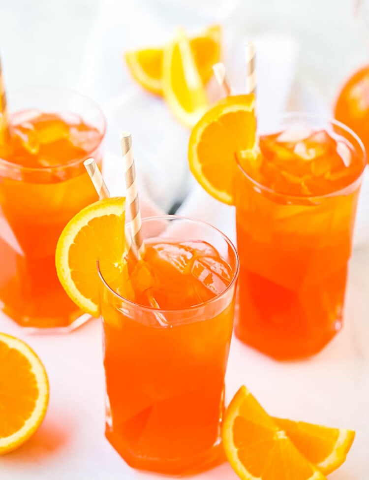 Three glasses of Aperol Spritz with orange slices