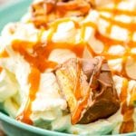 Bowl of Snicker Apple Salad topped with caramel sauce
