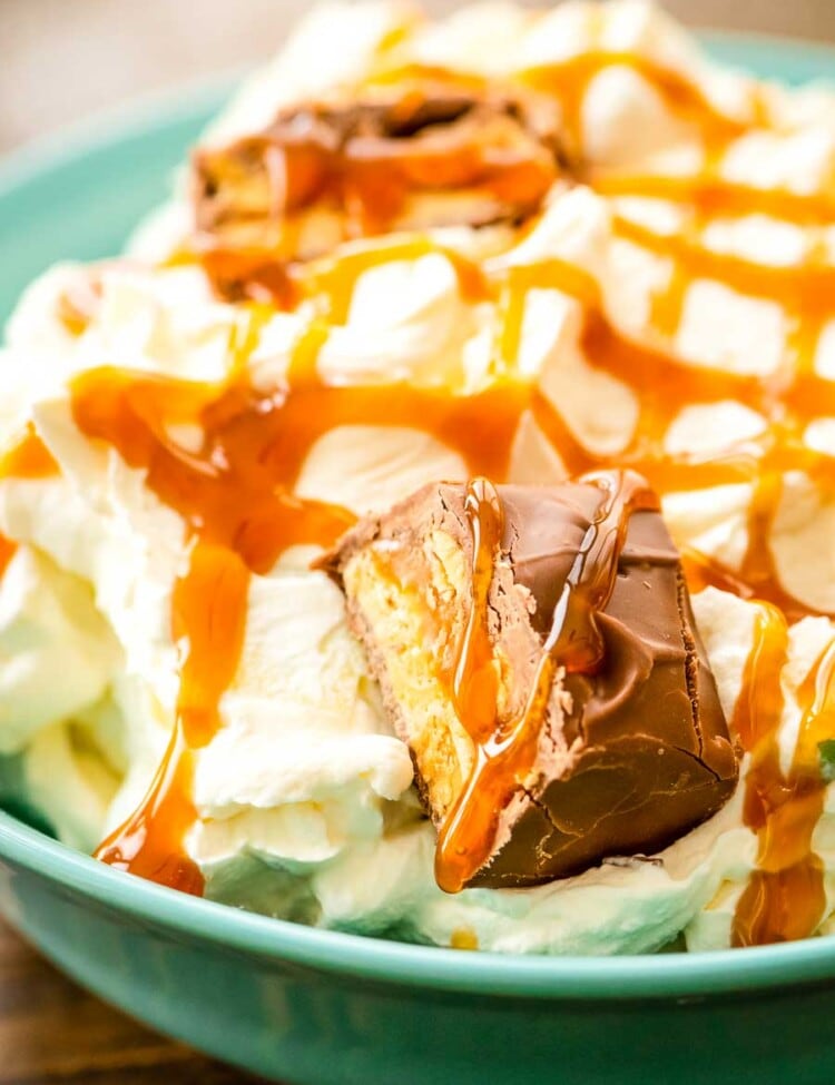 Bowl of Snicker Apple Salad topped with caramel sauce