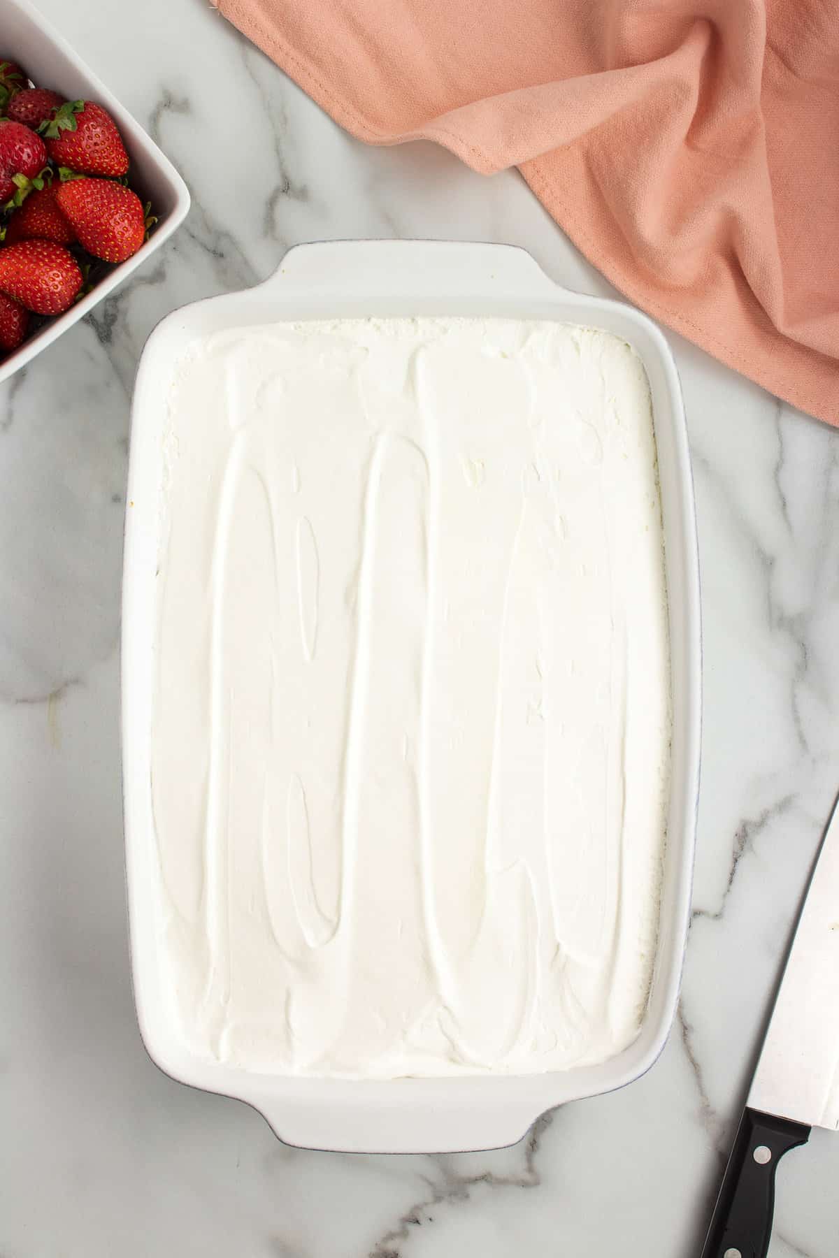 Overhead image of cake in dish with cool whip topping