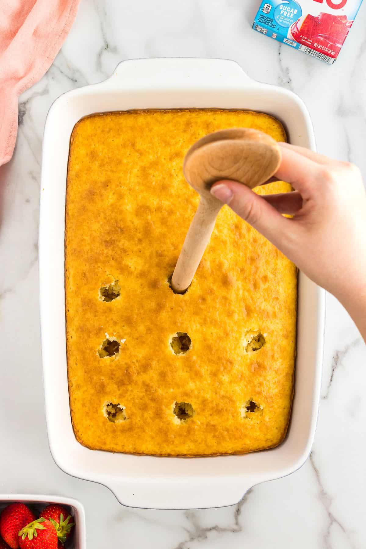 Poke holes in poke cake with spoon handle